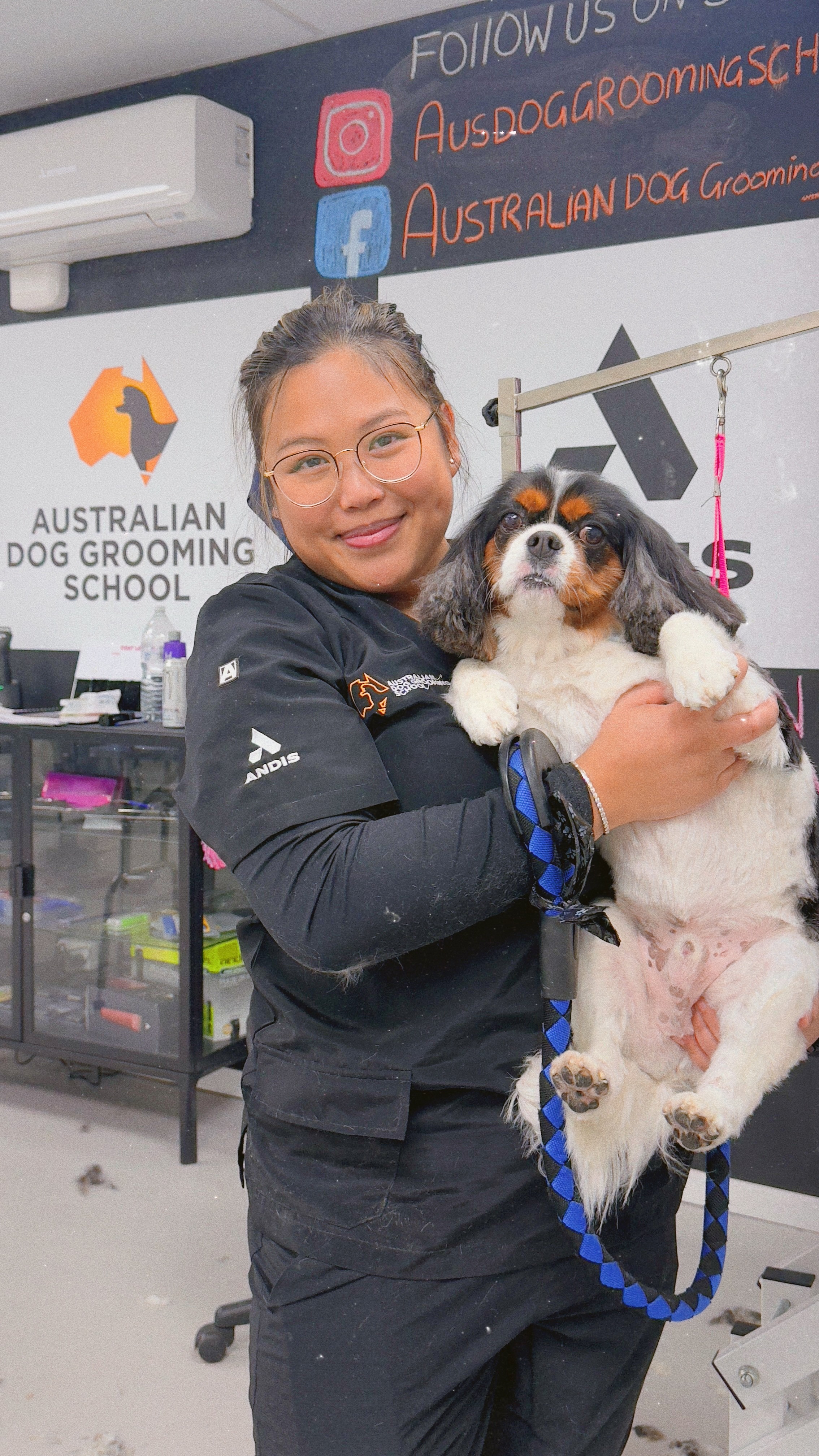 Kim holding a Cavalier King Charles Spaniel at the grooming school